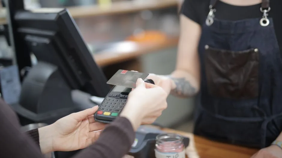 Cliente réglant ses achats au comptoir d’un commerce