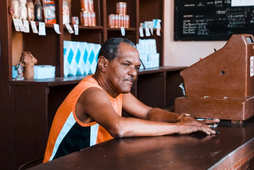 Commerçants au comptoir de leur boutique, carnet de caisse ouvert